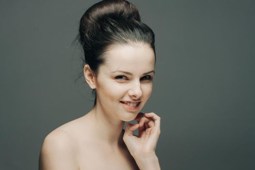 brunette with bare shoulders emotions glamor hand near face. High quality photo