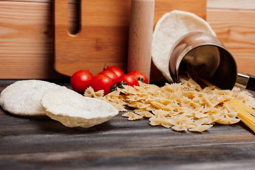 pasta on a wooden table cherry tomatoes kitchenware cooking. High quality photo