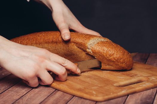 slicing a loaf on a wooden cutting board freshness. High quality photo