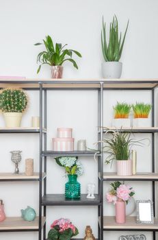 Flowers and decorative decorations on a metal rack in the style of minimalism in the living room in a Scandinavian style