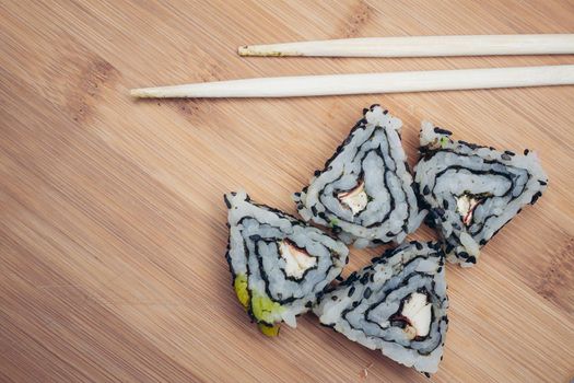 triangular sushi rolls chopsticks wood board japanese cuisine. High quality photo
