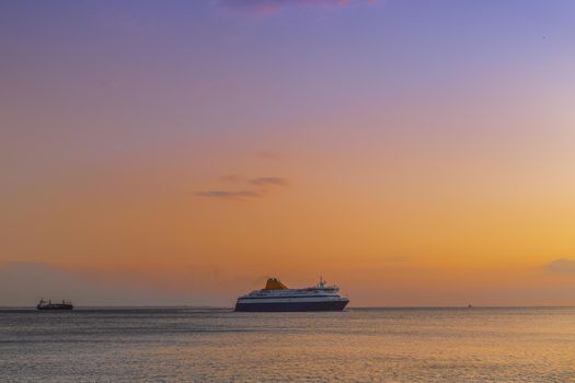 Evening view of commercial boat waiting to enter calm sea harbor.