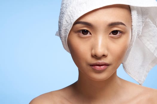 pretty asian woman clean skin care towel on head blue background. High quality photo
