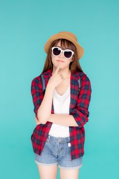 Beautiful portrait young asian woman wear sunglasses and hat having backpack smile confident enjoy summer holiday isolated blue background, tourist model girl thinking idea planning travel concept.