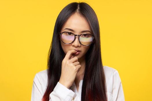 pretty woman wearing glasses elegant style attractive look finger near lips yellow background. High quality photo