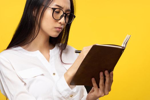 elegant woman holding notepad executive manager white shirt studio yellow background. High quality photo
