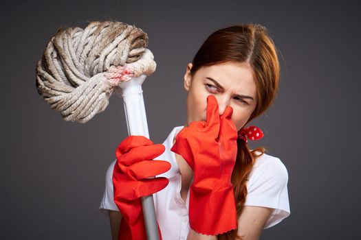 cleaning lady covers her nose with her fingers unpleasant smell mop in hand cleaning discontent. High quality photo