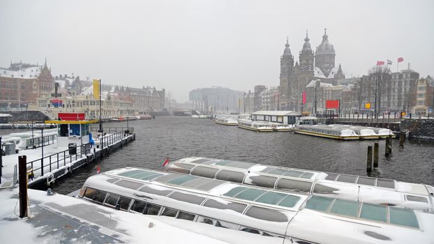 Snowy city Amsterdam in the Netherlands with the St. Nicolas church in winter
