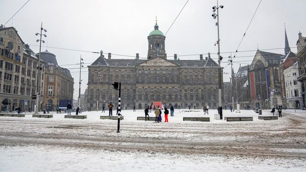 Snowy city Amsterdam at the Dam square in the Netherlands in winter