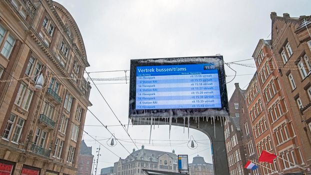 Cancelled trams in snowy and icy Amsterdam at Damrak in the Netherlands in winter