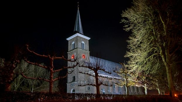 Snowy medieval church in Ternaard Friesland in the Netherlands at night