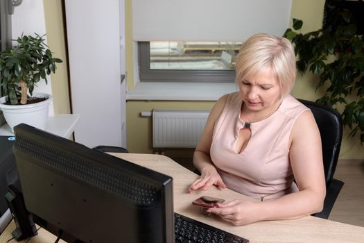 A female director working in an office is sitting at a table, analyzing business statistics, checking documents. Close-up.