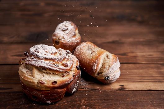 Traditional easter cake Kraffin stands on wooden table against a dark background. Spring holiday bread with copy space