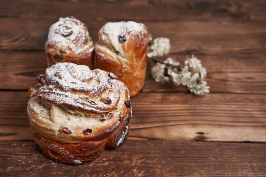 Traditional easter cake Kraffin stands on wooden table against a dark background. Spring holiday bread with copy space