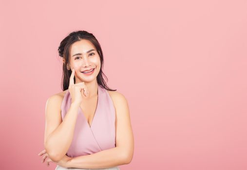 Portrait Asian beautiful young woman smiling standing chin handle relaxed thinking about something about the question studio shot isolated on pink background, Thai female idea think with copy space