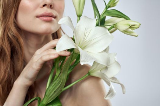 Portrait of a beautiful woman with white flowers on a light background. High quality photo