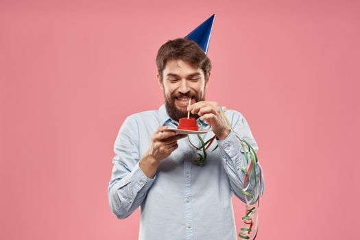 Birthday of a man with a cake and with a candle on a pink background. High quality photo