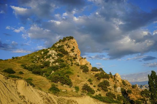 Balaclava. Crimea. Natural landscape with a high cliff covered with vegetation in the background of the cloudy sky.