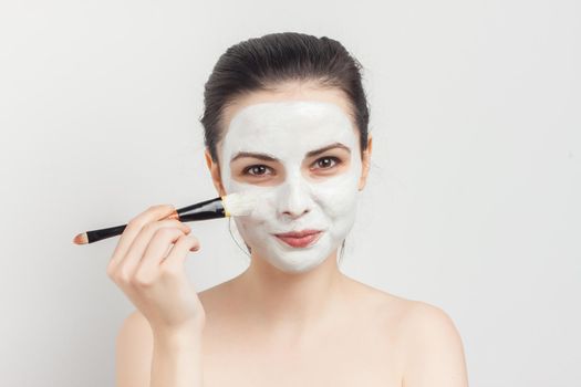 brunette with face mask naked shoulders skincare. High quality photo