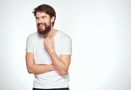 Emotional guy in a white t-shirt on a light background emotions model cropped view of a student. High quality photo