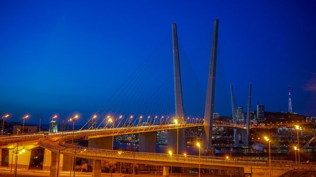 Golden bridge against the blue evening sky. Vladivostok, Russia