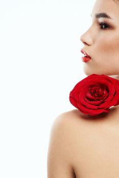 Back view of attractive brunette with red rose on naked shoulder. High quality photo