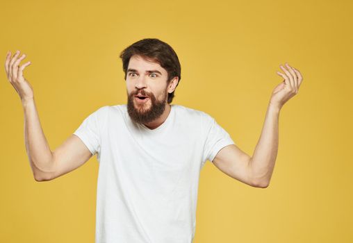 male model gesturing with his hands on a yellow background cropped view . High quality photo