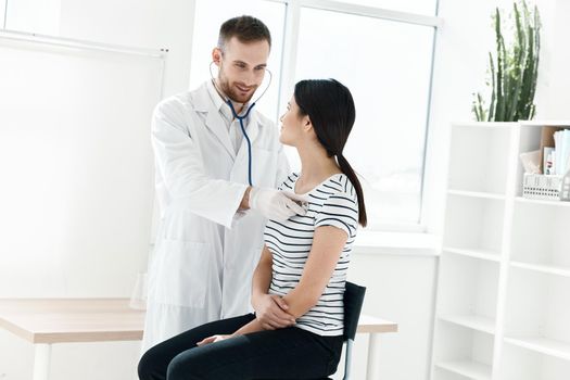 male doctor in white coat examining patient in hospital . High quality photo