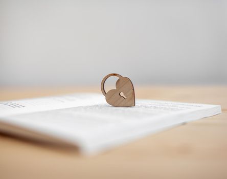 A wooden heart with a keyhole rests on an open book. There is a place for the text.