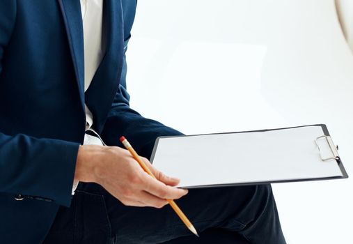 Business man in a suit with documents writes down important information. High quality photo