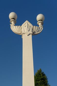 Sochi, Krasnodar region. Beautiful white stone lamppost on background of blue sky.