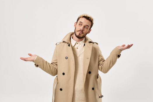 man gesturing with his hands fashion beige coat modern style studio. High quality photo