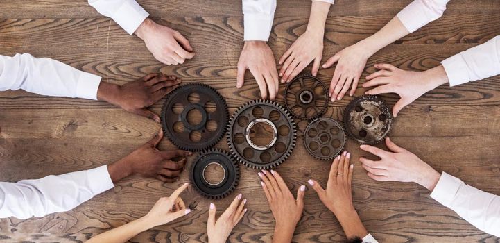 Top view of business people hands connecting gear cog coopertation teamwork unity concept