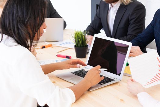 Diverse executive business people team discussing work results at meeting, multiracial businessmen talking analyzing financial statistics report sitting together in modern office with laptop and documents