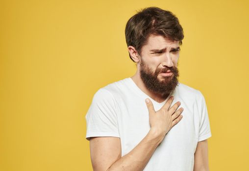 A brunette man with a thick beard on a yellow background emotions model. High quality photo