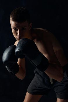 man in boxing gloves on black background workout bodybuilder fitness. High quality photo