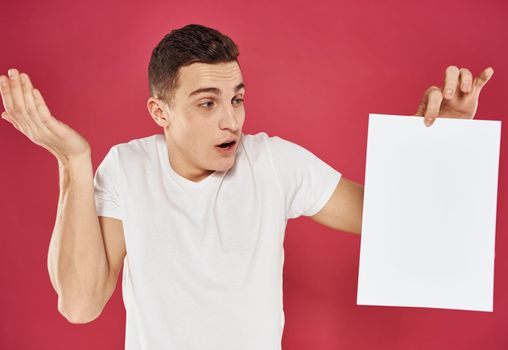 Man with a flyer in his hand on a red background advertising mockup. High quality photo