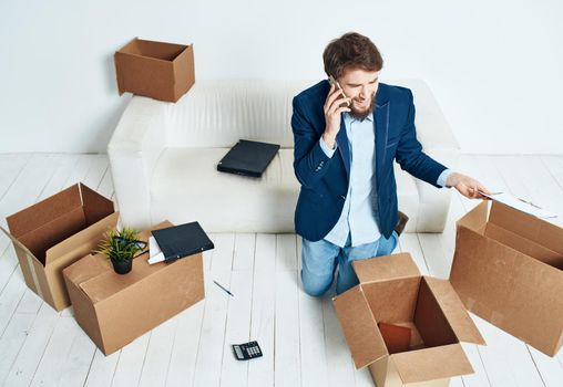 man talking on the phone unpacking boxes office work new place businessman. High quality photo