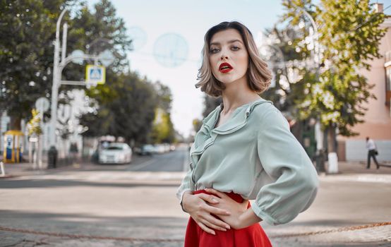 a woman in a shirt skirt strolls through the central streets of the city and tall buildings in the background. High quality photo