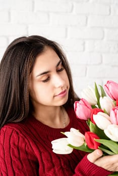 Valentine's Day and Women's Day. Small business. Beautiful brunette woman smelling fresh tulips