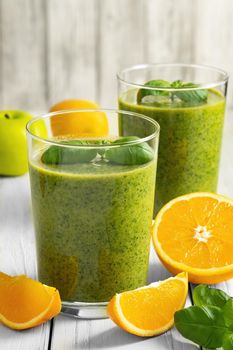 Healthy green smoothie with spinach, mango, orange,lime, apple,citrone in glass jars.