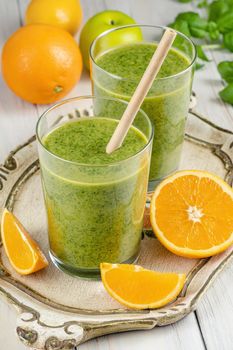 Healthy green smoothie with spinach, mango, orange,lime, apple,citrone in glass jars.