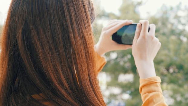 woman with phone in hand takes pictures of nature on camera vacation landscape. High quality photo