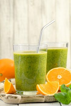 Healthy green smoothie with spinach, mango, orange,lime, apple,citrone in glass jars.