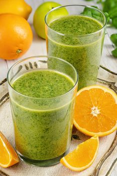 Healthy green smoothie with spinach, mango, orange,lime, apple,citrone in glass jars.