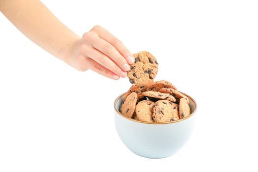 Young woman holding tasty chocolate chip cookie over bowl on white background, closeup