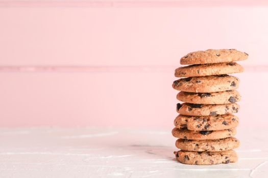 Stack of tasty chocolate chip cookies on wooden background. Space for text