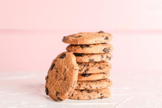 Stack of tasty chocolate chip cookies on wooden background. Space for text