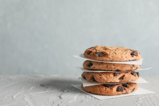 Tasty chocolate chip cookies on gray background