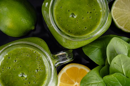 Healthy green smoothie with spinach, mango, orange,lime, apple,citrone in glass jars top view